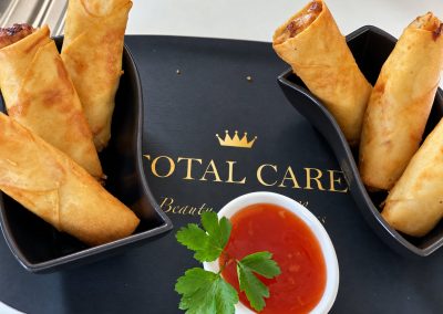Loempia's met zoetzure saus op een bord van Total Care